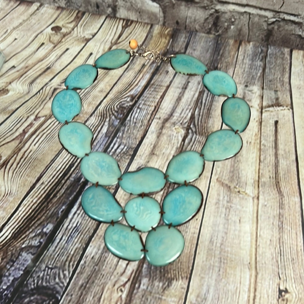 Turquoise colored necklace made from seed pods.